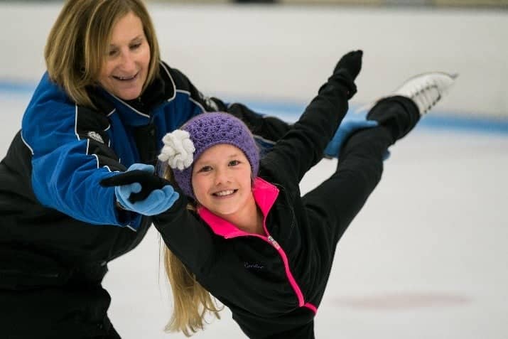 Female coach helping a young female athlete with a spiral 