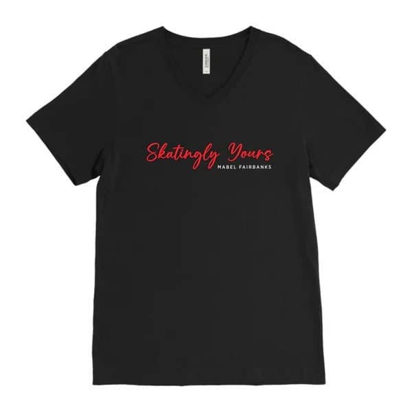 Image of a black tshirt that says Skatingly Yours in red and Mabel Fairbanks below it in white 